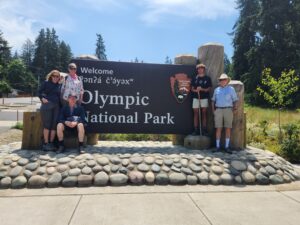 Photo of a family standing in front of the Olympic National Park sign