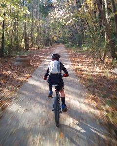 Child riding rail-trail with backpack