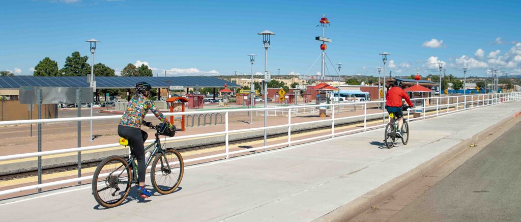 Cyclists riding along the train tracks that connect Santa Fe and Albuquerque.