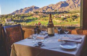 Photo of the table in a restaurant in tucson arizona with place settings and a bottle of wine