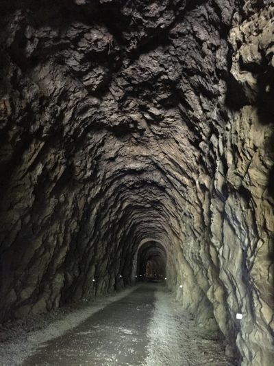 Riding a bike through tunnel on Hiawatha Trail on Idaho Bike Tour with Wilderness Voyageurs Bike Tours