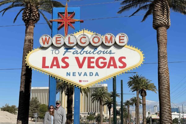 photo of two people standing in front of the welcome to fabulous las vegas sign